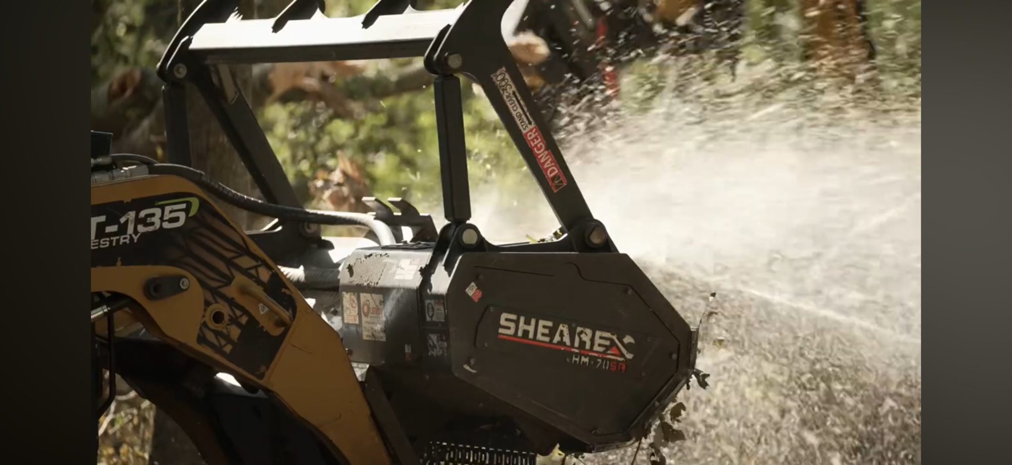 Close view of a forestry mulching head mounted on a track loader
