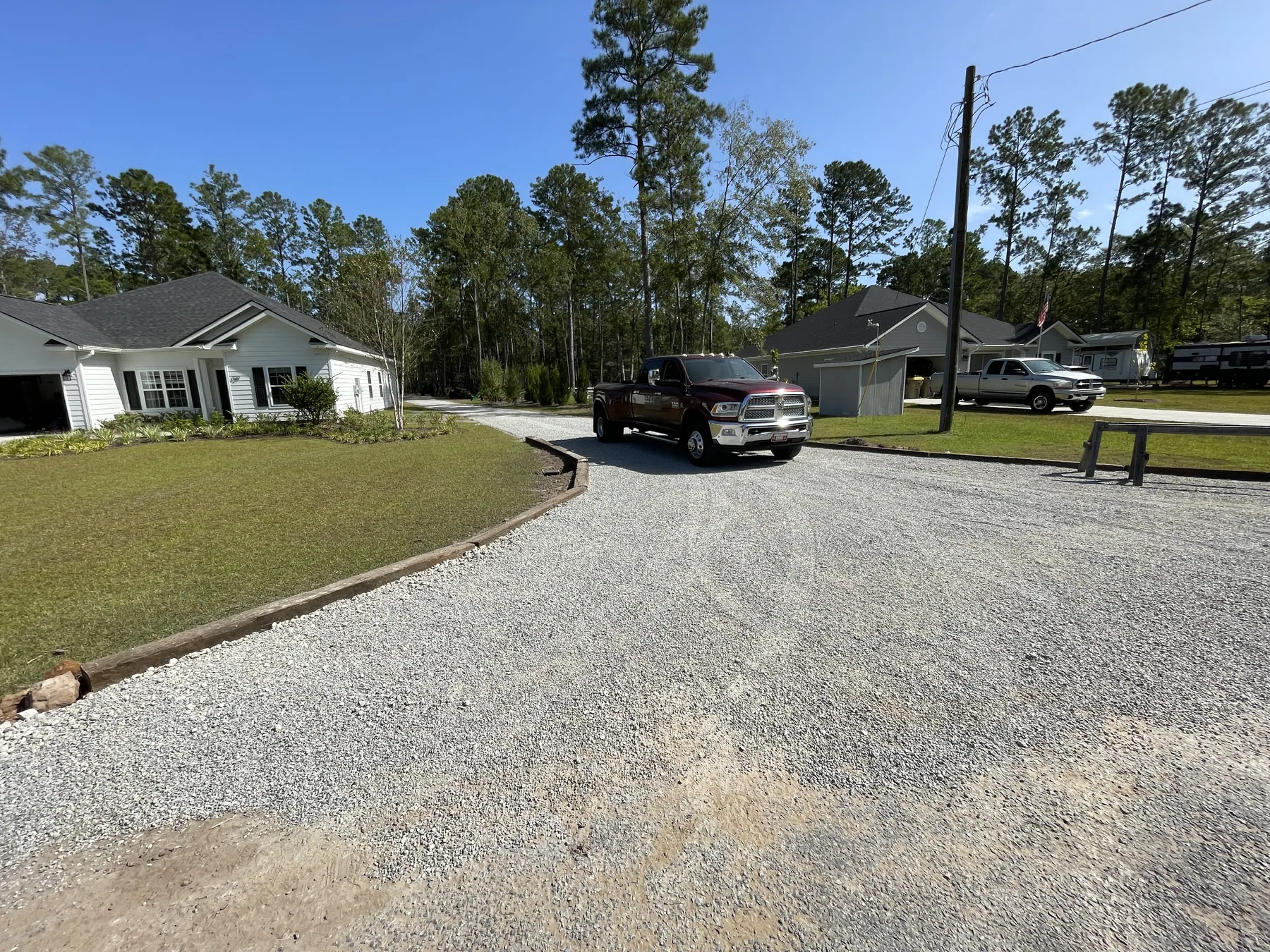 Finished gravel driveway entry running into a wooded property