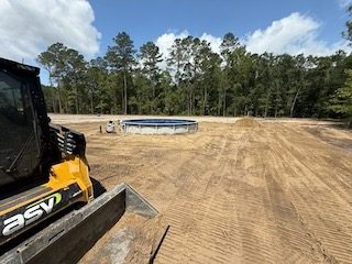 Track machine grading a building pad smooth