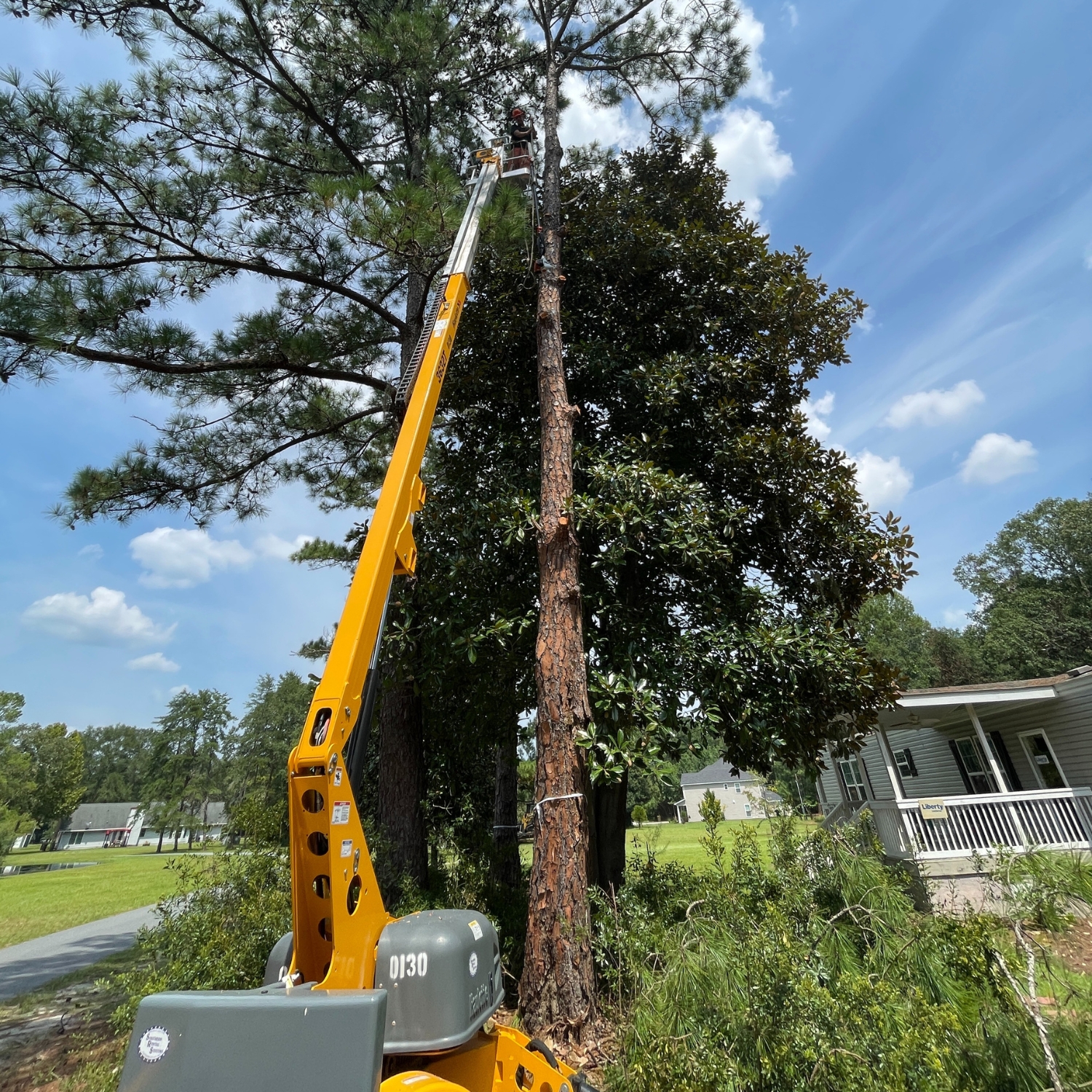 Crew clearing downed storm timber from a rural driveway