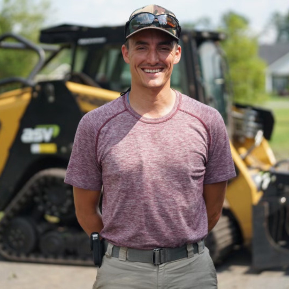 Owner operator of Cleared to Land/Scape standing beside his mulching machine